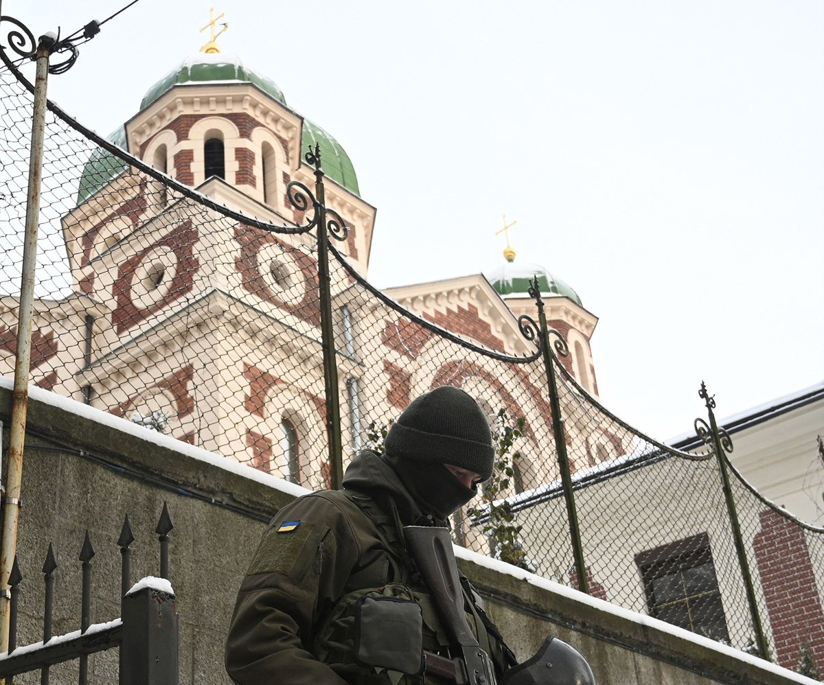 Сотрудник службы безопасности Украины у Георгиевского собора Львова во время обыска, 14 декабря 2022 года. Фото: Юрий Дячишин / AFP / Scanpix / LETA